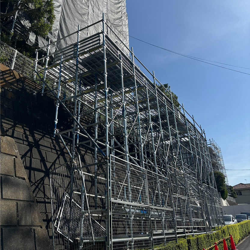 擁壁の上に建つ建物の足場工事